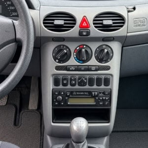 Mercedes A-Klasse W168 Mittelkonsole mit rechteckigem Werksradio, Ablagefach darunter und drei Heizungsreglern oberhalb.