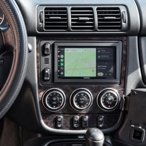 Mercedes ML W163 Mittelkonsole mit nachgerüstetem Kenwood-Doppel-DIN-Radio, Navigationsanzeige und schwarzem Zierrahmen.