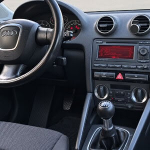 Audi A3 8P Cockpit mit werkseitigem Audi Navigation Doppel-DIN-Radio, rotem Display und Bedientasten in der Mittelkonsole.