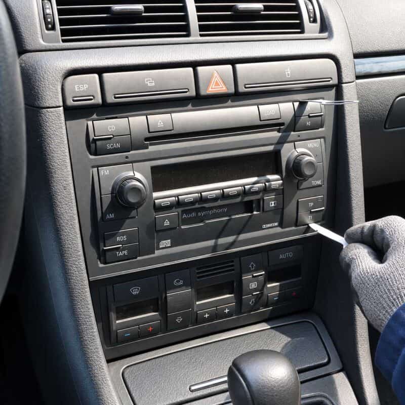 Entriegelungsbuegel in die Schlitze am Radio rechts unten einfuehren