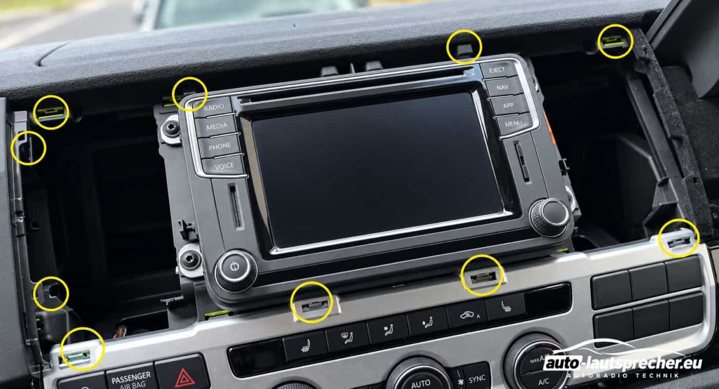 VW T6 ab 2015 mit abgenommenem Radiorahmen und zehn gelb markierten Befestigungspunkten für die Halteclips.