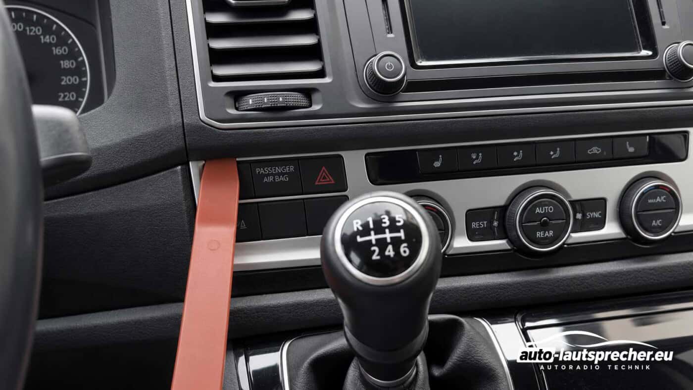 Kunststoffhebel an der linken unteren Kante des Radiorahmens im VW T6 ab 2015 zum Lösen der Halteclips.