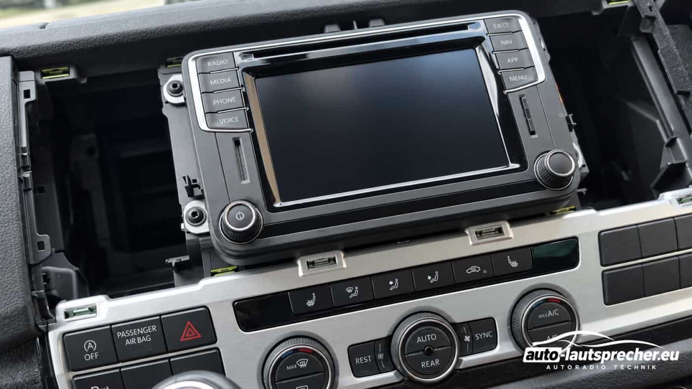 VW T6 ab 2015 ohne Radiorahmen und Lüftungsdüsen, mit noch eingebautem Werksradio und freiliegenden Befestigungsschrauben.