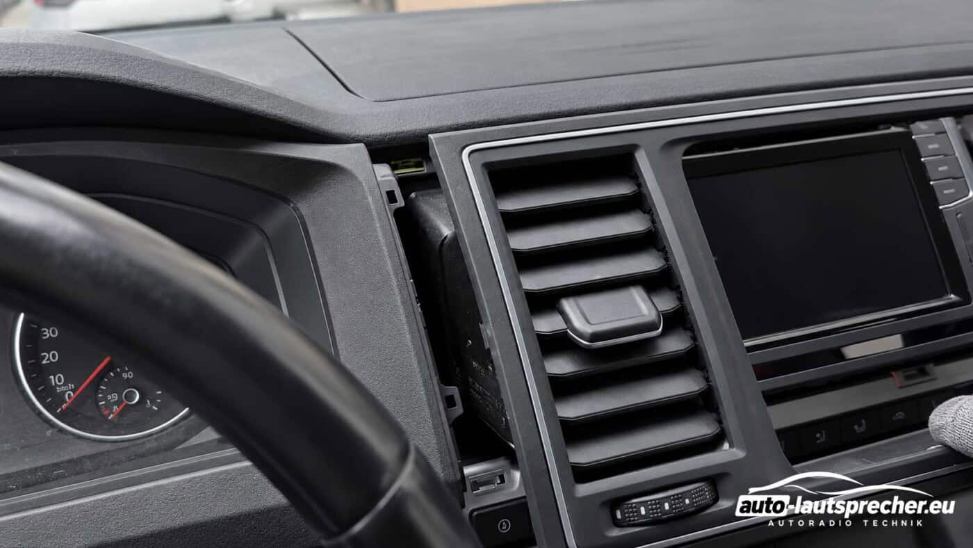 Gelöster Radiorahmen mit integrierten Lüftungsdüsen im VW T6 ab 2015, nach vorne aus der Mittelkonsole gezogen.